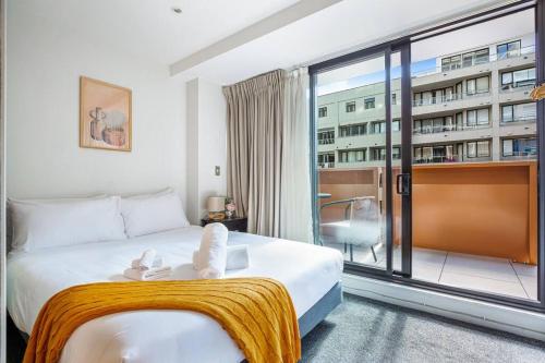 a hotel room with a bed and a large window at Sleek central apartment with a private balcony in Auckland