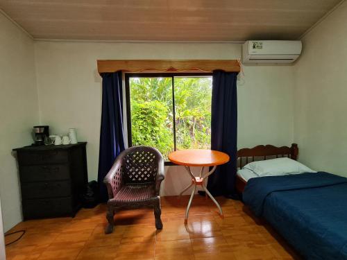 德雷克的住宿－Osa Corcovado Lodge，一间卧室配有桌子、床和窗户