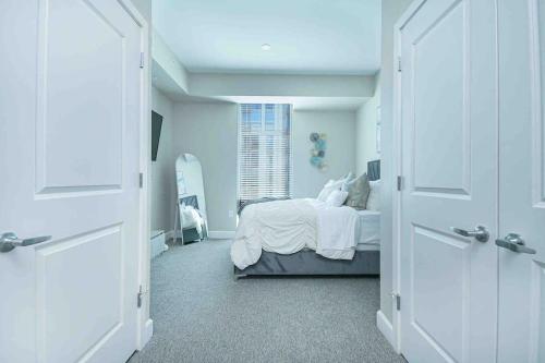 a white bedroom with a bed and a window at The Bleu Oasis in Atlanta