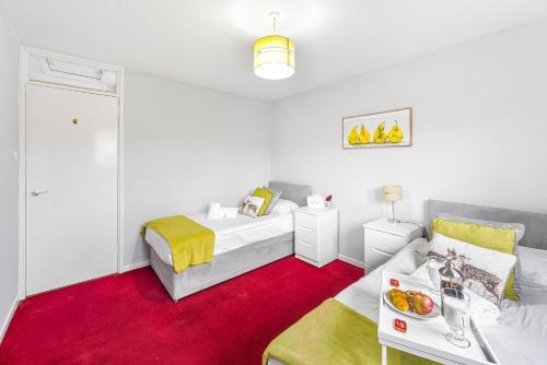 a white bedroom with a bed and a red carpet at Premier - Maryhill Apartment in Glasgow