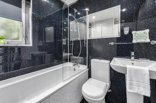a bathroom with a toilet and a sink and a shower at Premier - Maryhill Apartment in Glasgow