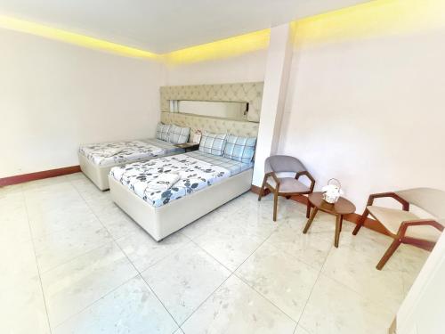 a bedroom with two beds and a table and chairs at GTC Pension House in Santa Rita