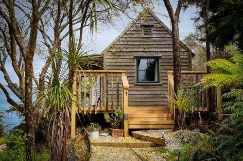 a wooden cabin with a porch and a window at Te Tiro Accommodation in Waitomo Caves