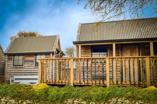 a house with a wooden deck next to a house at Te Tiro Accommodation in Waitomo Caves