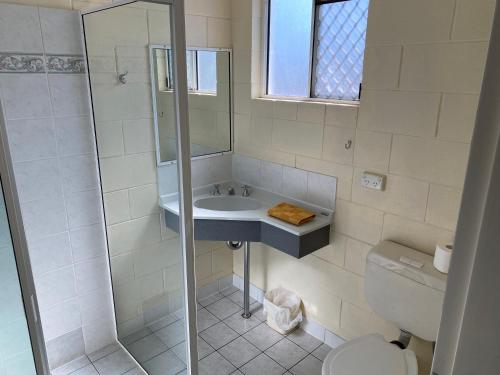 ein Bad mit einer Dusche, einem Waschbecken und einem WC in der Unterkunft Central Point Motel in Mount Isa