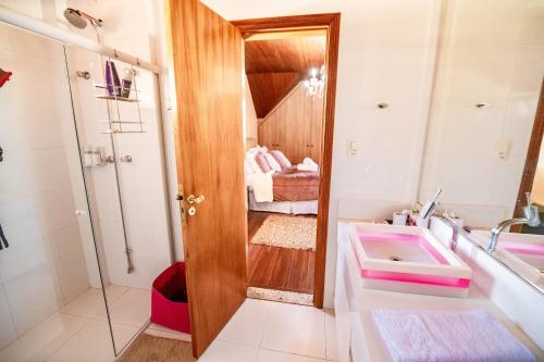 La salle de bains est pourvue d'un lavabo et d'un miroir. dans l'établissement Luxuoso duplex no Capivari, à Campos do Jordão