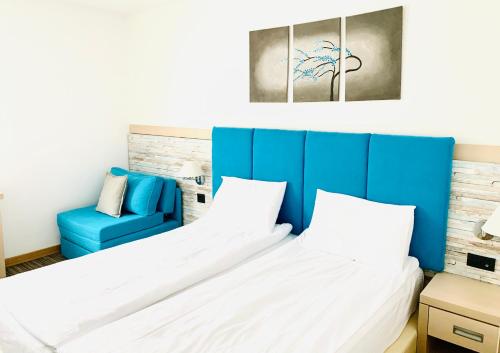 een slaapkamer met een bed en een blauwe stoel bij MONI Luxury Apartments in Kopaonik