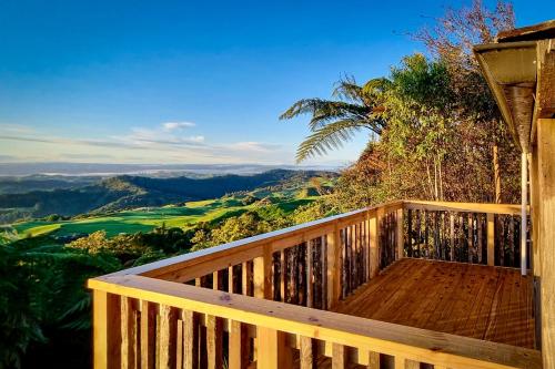 a wooden deck with a view of the mountains at Te Tiro Accommodation in Waitomo Caves