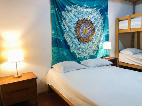 um quarto com duas camas e uma tapeçaria na parede em Casa Mauka Habitación múltiple em Los Órganos