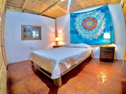 1 dormitorio con 1 cama grande y una pintura en la pared en Casa Mauka Habitación múltiple, en Los Órganos