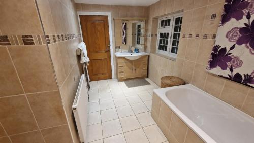 a bathroom with a tub and a sink at Comfort Sleep - Rooms with shared facilities in Windsor
