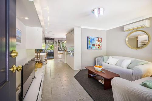 a living room with a couch and a table at Secret Garden Cottage Busselton in Busselton