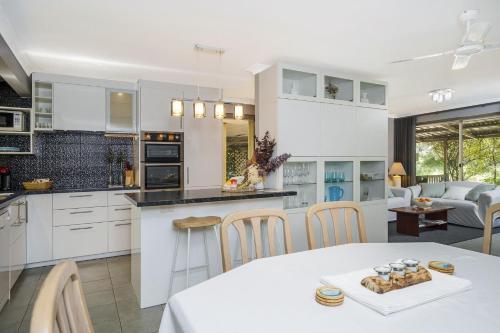 a kitchen and living room with a table and chairs at Secret Garden Cottage Busselton in Busselton