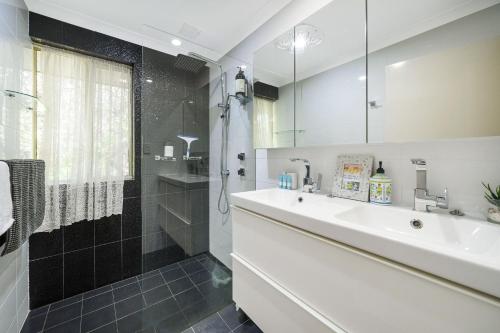 a bathroom with a sink and a shower at Secret Garden Cottage Busselton in Busselton