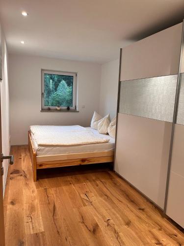a bedroom with a bed and a window at Ferienwohnung Trissl in Oberaudorf