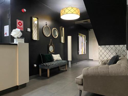 a living room with a couch and clocks on the wall at U Hotel Villa-Gomá in Zaragoza