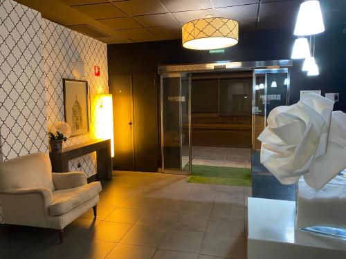 a lobby with a chair and a glass door at U Hotel Villa-Gomá in Zaragoza
