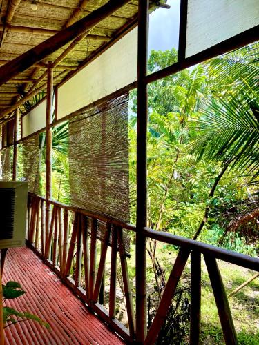 - un balcon offrant une vue sur une maison dans la jungle dans l'établissement Kasa Raya Inn, à Tibiao