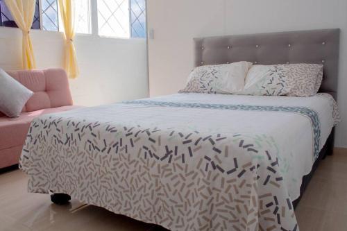 a bedroom with a bed with a black and white comforter at Apartamento con la mejor ubicación Cali in Cali