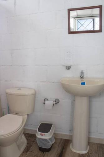 a white bathroom with a toilet and a sink at Apartamento con la mejor ubicación Cali in Cali