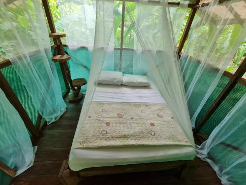 Bett in einem Zimmer mit Moskitonetzen in der Unterkunft Rio Agujitas Eco jungle - Island and Corcovado tours in Drake