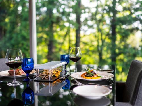 a table with plates of food and wine glasses at Hakone Fontaine Bleau Sengokutei in Hakone