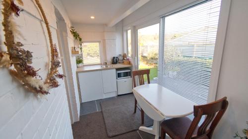 a kitchen with a table and chairs and a window at Cosy on Stirling in Oamaru