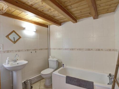 Un baño con inodoro, lavabo y bañera. en Gîte spacieux avec terrasse, poêle à bois, parking privé, et jardin fermé, animaux acceptés - FR-1-496-28, en Saint-Bonnet-le-Courreau