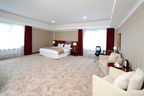 a hotel room with a bed and a couch at Alpha Hotel Ulaanbaatar in Ulaanbaatar