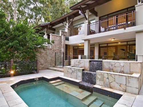 een huis met een zwembad voor een huis bij Pullman Palm Cove Sea Temple Resort & Spa in Palm Cove