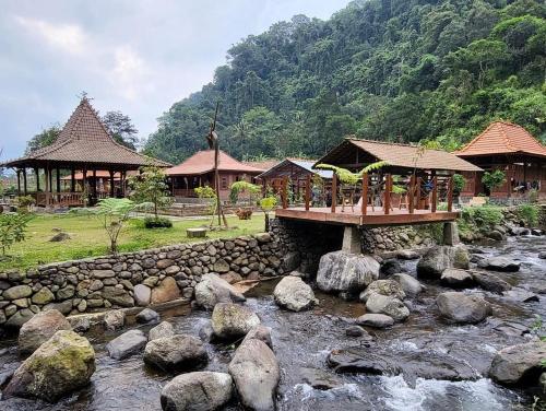 eine Brücke über einen Fluss neben einem Berg in der Unterkunft Rumah Lembah Bogor 