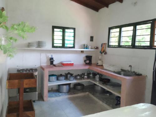 una cocina con mesa y fregadero. en Mágica Cabaña familiar cerca al mar, en Coveñas