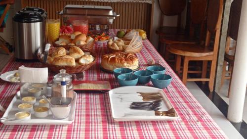 uma mesa com uma toalha de mesa vermelha e branca com alimentos em POUSADINHA LITORAL em Mucuri