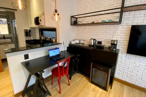 a kitchen with a desk with a laptop on it at Loft lindo e aconchegante no centro de Teresópolis in Teresópolis