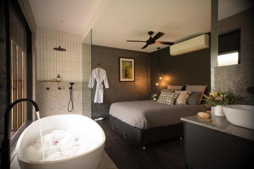 Cheshunt的住宿－Sambar Hills- Kings #3，一间带床和浴缸的浴室以及一间卧室
