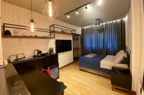 um quarto com uma cama e uma secretária com um lavatório em Loft lindo e aconchegante no centro de Teresópolis em Teresópolis