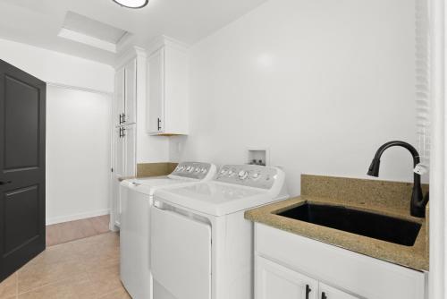 a white kitchen with a sink and a dishwasher at Safari Vines Retreat in Escondido