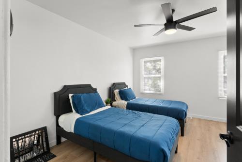 two beds in a room with a ceiling fan at Safari Vines Retreat in Escondido