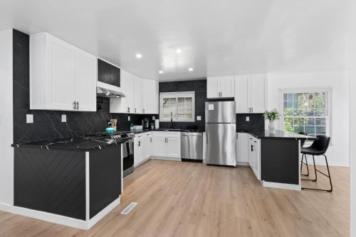 a kitchen with white cabinets and black counter tops at Safari Vines Retreat in Escondido