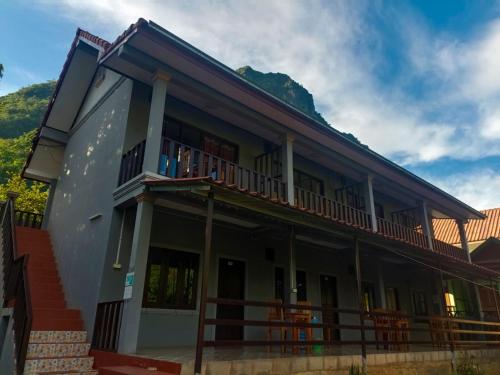 un bâtiment avec un balcon donnant sur les montagnes en arrière-plan dans l'établissement Khamphan Guesthouse, à Nongkhiaw