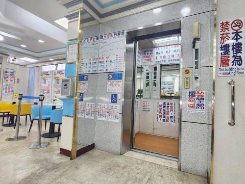 an elevator in a restaurant with signs on the wall at Hua Ku Hotel in Tainan