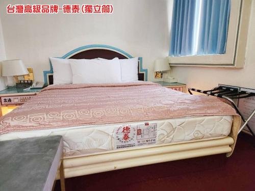 a bedroom with a large bed with two night stands at Hua Ku Hotel in Tainan