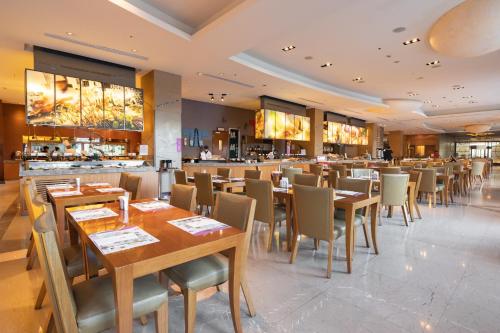 a restaurant with wooden tables and chairs and a bar at E-DA Royal Hotel in Dashu