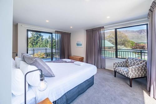 ein Schlafzimmer mit einem Bett und einem großen Fenster in der Unterkunft Elevated Mountain Views in Wanaka