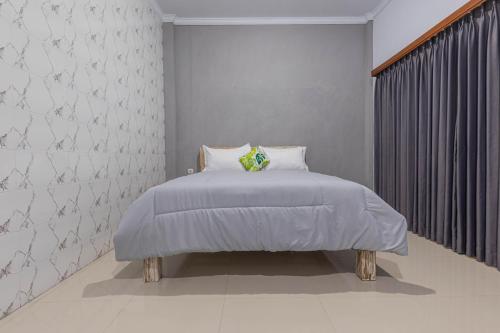Dormitorio blanco con cama y ventana en Bali DD homestay seminyak, en Seminyak