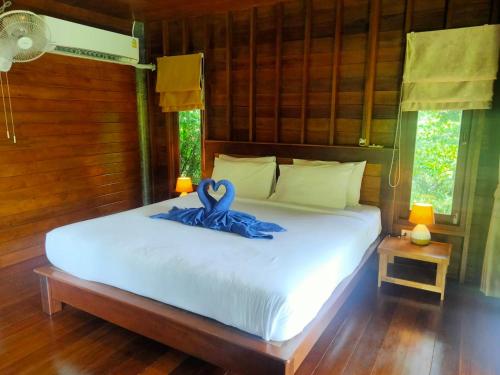 Un dormitorio con una cama con una cinta azul. en Sabai House Bungalow, en Ko Yao Noi