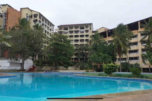une piscine vide en face d'un bâtiment dans l'établissement Beachfront / Air-con / king bed / pool, à Ukunda