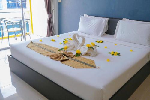 a bed with flowers and ribbons on it at โรงแรมศุภชัย อินน์ in Ban Ba Ngan