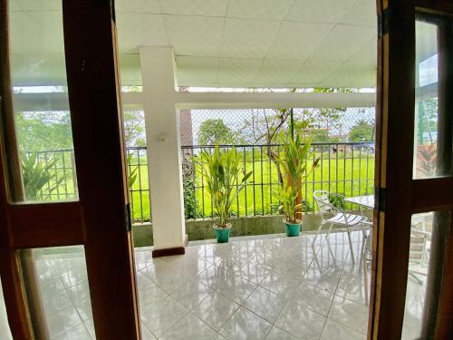 an open door to a balcony with potted plants at Green Villa in Oluvil