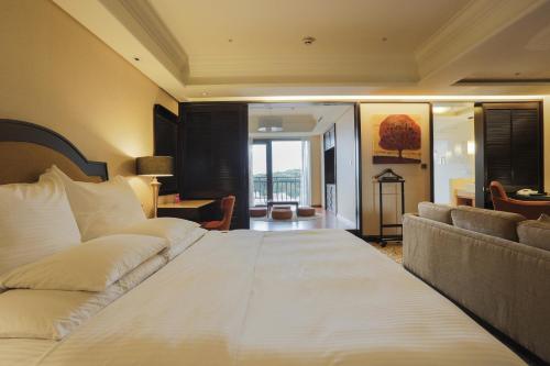 a bedroom with a large white bed and a couch at E-DA Royal Hotel in Dashu